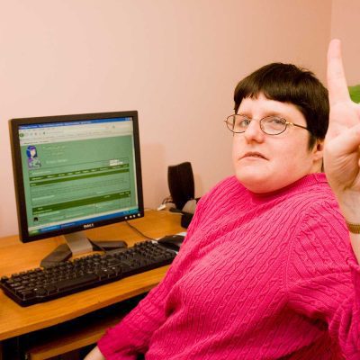 client using a computer giving the peace sign