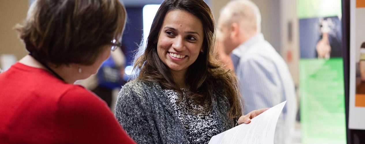 smiling woman looking at a booklet